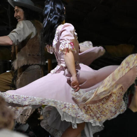 ardancer_mlleone A woman dancing in a long pink skirt with a man dressed in brown.